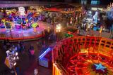 View into the dark Super 89's exhibition hall, from which colorful rides shine out.